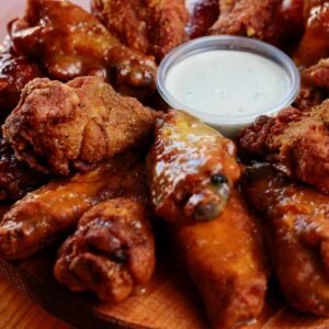 Close-up of assorted buffalo chicken wings served with a creamy dipping sauce.